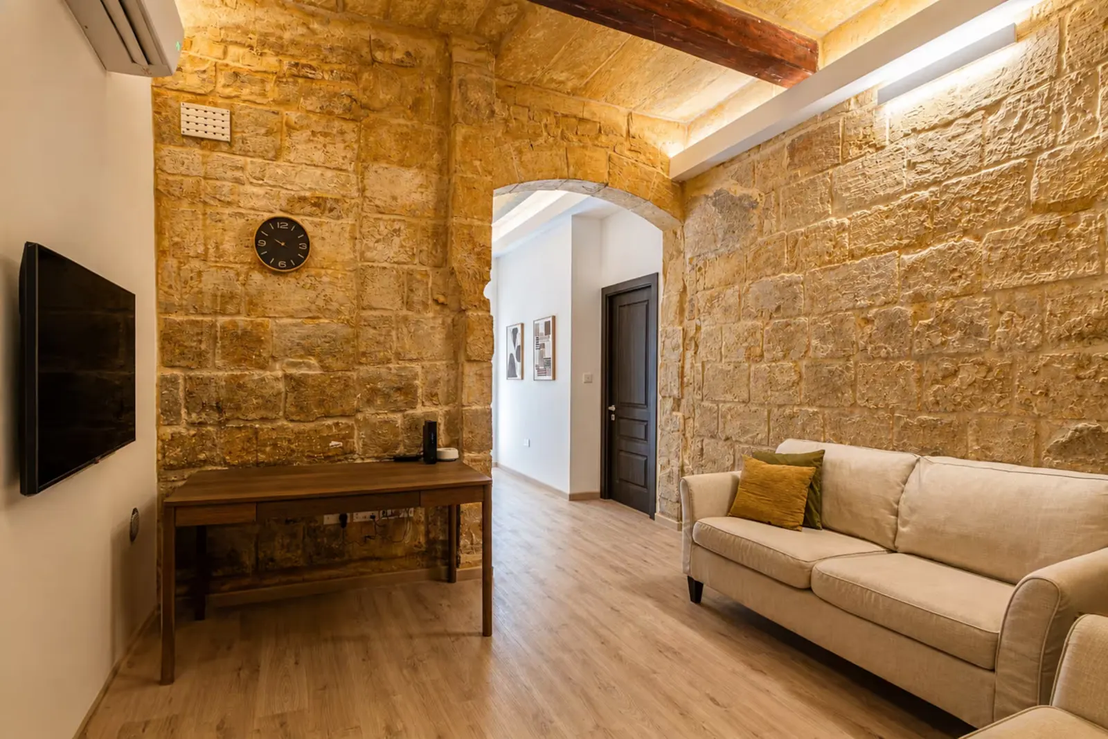 Living room with desk, TV and arched doorway